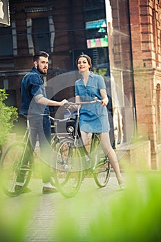 Young couple sitting on a bicycle opposite the