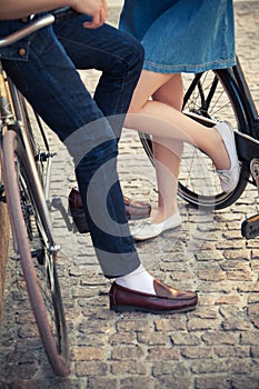 Young couple sitting on a bicycle opposite the