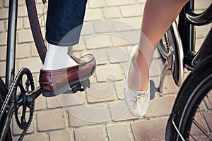 Young couple sitting on a bicycle opposite the