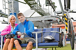 Young couple sitting chair lift waiting departing photo