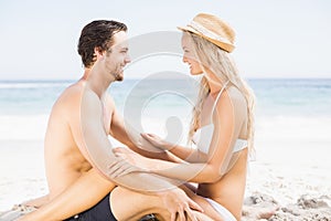 Young couple sitting face to face on the beach
