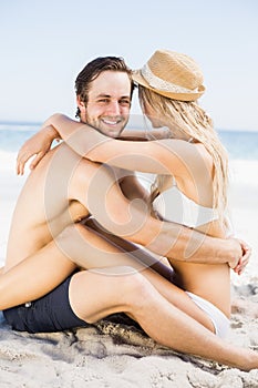 Young couple sitting face to face on the beach