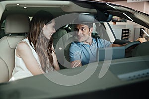 Young couple sitting inside new car