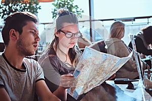 A young couple sitting in an outdoor caf planning to itinerary their journey