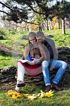 Young couple sitting in the park and reading.