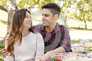 Young couple sitting at a picnic table in a park