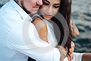 Young couple are sitting on the pier by the sea