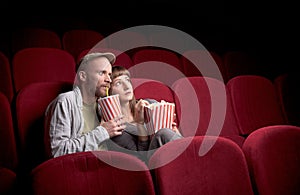 Young couple sitting at red movie theatre