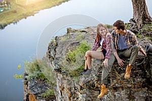Young couple sitting on a rock having a conversation