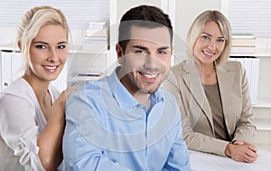 Young couple sitting in a sales conversation at bank or insurance.