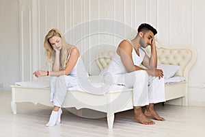 Young Couple Sitting Separate On Bed, Having Conflict Relationships Problem, Sad Negative Emotions Hispanic