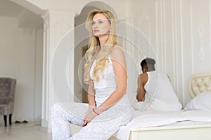 Young Couple Sitting Separate On Bed, Having Conflict Relationships Problem, Sad Negative Emotions Hispanic