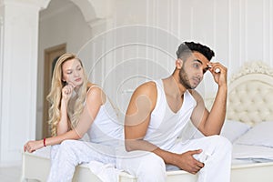 Young Couple Sitting Separate On Bed, Having Conflict Relationships Problem, Sad Negative Emotions Hispanic Man And