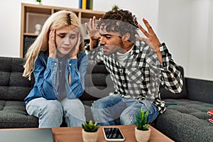 Young couple sitting on the sofa discussing at home
