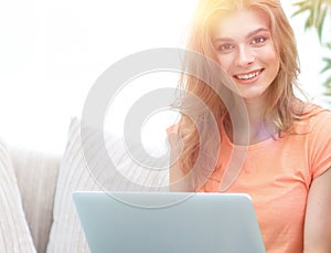 Young couple sitting on sofa and looking at pictures on the laptop.