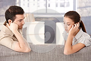 Young couple sitting on sofa sadly photo