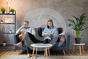 Young Couple Sitting on the Sofa. The Woman Tears Up The Photo. Family Conflict.