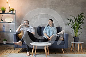 Young Couple Sitting on the Sofa. The Woman Tears Up The Photo. Family Conflict.