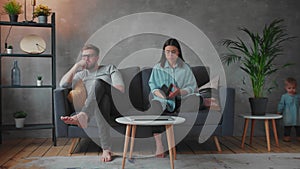Young Couple Sitting on the Sofa. The Woman Tears Up The Photo. Family Conflict.