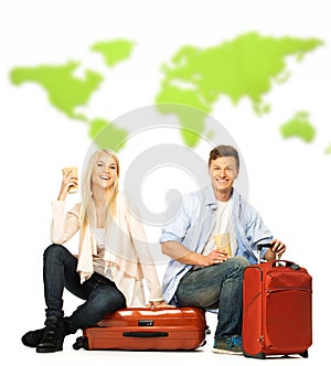 Young couple sitting on suitcases