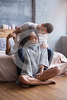 Young couple sitting together in a bedroom