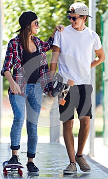 Young couple skateboarding in the street.