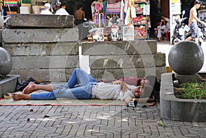 A young couple sleep on the streets of Hanoi in each other's arms