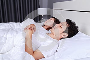 Couple sleeping on a comfortable bed in bedroom at home