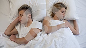 Young couple sleeping peacefully on comfortable orthopedic mattress, relax dream
