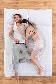 Young couple sleeping together on bed