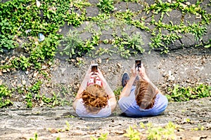 Young couple with smartphones in town.