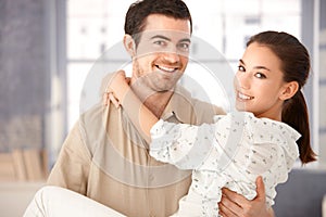 Young couple smiling happily holding each other