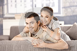 Young couple smiling happily on sofa at home photo