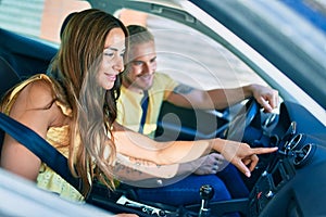 Young couple smiling happy driving car and using gps navigator smartphone