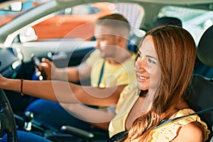 Young couple smiling happy driving car and using gps navigator smartphone