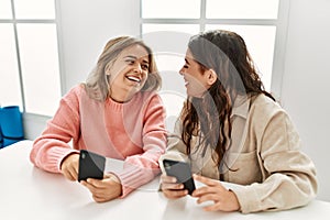 Young couple smiling happy using smartphohe at home