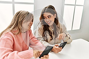 Young couple smiling happy using smartphohe at home