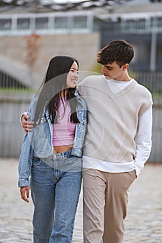 Young couple smiling while walking together outdoors.