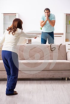 Young couple and snake in the flat