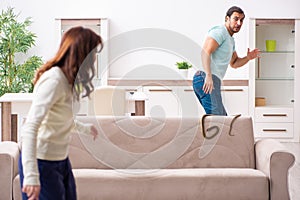 Young couple and snake in the flat