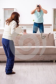 Young couple and snake in the flat