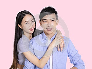 Young couple sniling and hugging together isolated on pink background