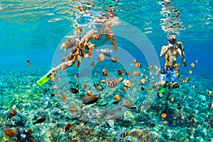 Young couple in snorkeling mask dive underwater in tropical sea