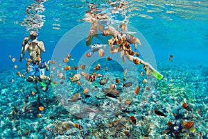 Young couple in snorkeling mask dive underwater in tropical sea