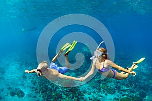 Young couple in snorkeling mask free dive underwater in sea