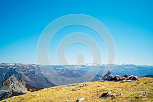 Young couple spending free time in national park/mountains,lying on a meadow.Hiking outdoor experience.Enjoying leisure on picnic