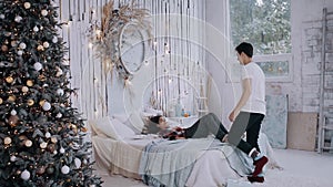 Young couple spending time at home in the Christmas bedroom.