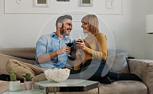 Young couple spending time together at home. Man and woman sitting on the couch and having fun