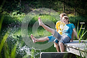 Young couple splashing water at lake