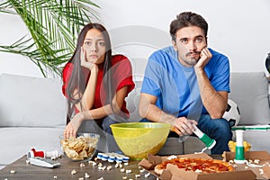 Young couple sport fans watching match boring game